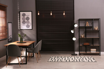 Stylish room interior with comfortable furniture and shelving unit. Modern design