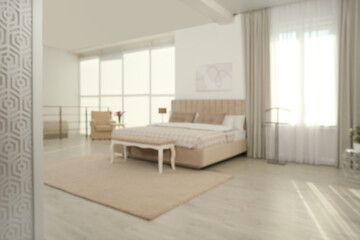 Fototapeta na wymiar Blurred view of stylish hotel bedroom interior with modern furniture