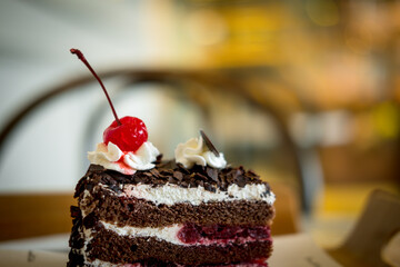 Black forest cake decorated with whipped cream and cherries