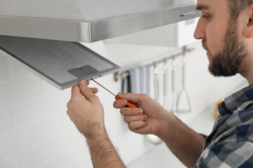 Man repairing modern cooker hood indoors, closeup