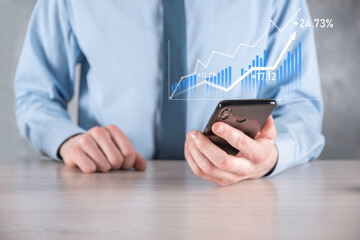 Businessman man holding a graph with positive profits growth. plan graph growth and increase of chart positive indicators in his business.more profitable and growing