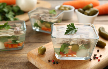 Delicious aspic with meat in bowl on wooden table. Space for text