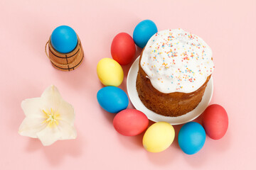 Easter cake on a plate, eggs and tulip flower with pink background.