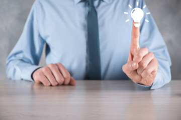 Businessman in a suit with a light bulb in his hands. Holds a glowing idea icon in his hand. With a place for text