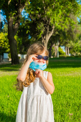 Adorable little girl in a protective mask
