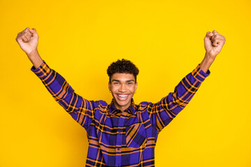 Fototapeta premium Photo of young excited black guy happy positive smile rejoice victory fists hands isolated over yellow color background
