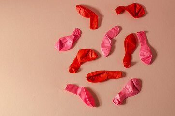 Minimalistic composition with deflated balloons on a pink backgr