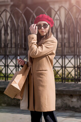 Young beautiful woman with long brown hair in sunglasses on a walk on a cloudy day. Fashionable sexy girl. Street fashion look. Cute student. Shopping.