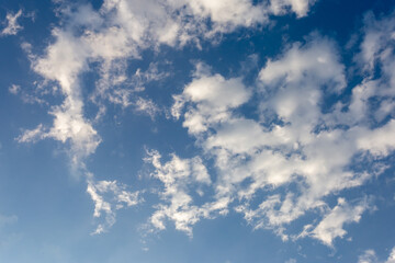 There are many beautiful floating white clouds and clear blue sky with light shining through the clouds. Sky images for blue background design make you feel fresh and bright.