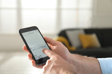 Man writing message I Love You on smartphone against blurred background, closeup. Space for text