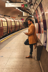 Man in a long coat waiting on subway platform