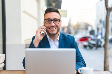 Fototapeta premium Businessman Having Phone Call in a Cafe Outdoors.