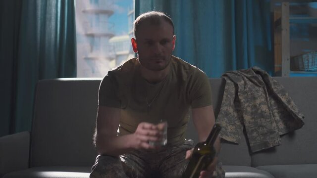portrait professional military man sits in depression and frustration with alcohol and drinks