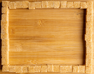Brown sugar on the wooden table. Background and textures. Shot from above.
