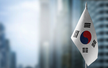 A small flag of South Korean on the background of a blurred background - obrazy, fototapety, plakaty