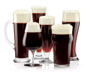 Set of fresh stout beer glasses with bubble froth isolated on white background.