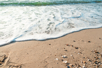 Fototapeta na wymiar Close Up Wave Sand Beach Sea Foam. Closeup of sea wave with foam on beach sand. Vacation Summer background 