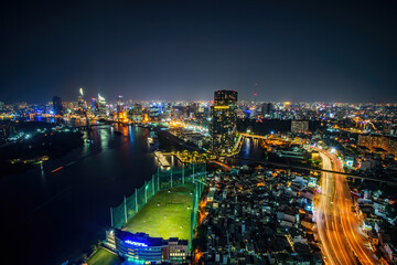 Fototapeta premium Aerial view of Ho Chi Minh city, Vietnam. Beauty skyscrapers along river light smooth down urban development. Dramatic lighting spectacular night.