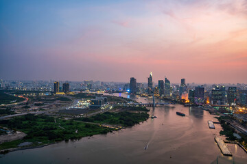Fototapeta na wymiar Aerial view of Ho Chi Minh city, Vietnam. Beauty skyscrapers along river light smooth down urban development. Dramatic lighting spectacular sunset.