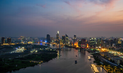 Obraz premium Aerial view of Ho Chi Minh city, Vietnam. Beauty skyscrapers along river light smooth down urban development. Dramatic lighting spectacular night.
