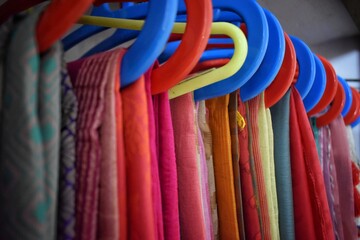 Closeup view of saris or sarees hung on hangers in display of retail shop,india culture and...