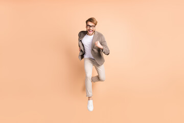 Fototapeta na wymiar Full size photo of excited happy positive man jump up runner sale travel isolated on beige color background