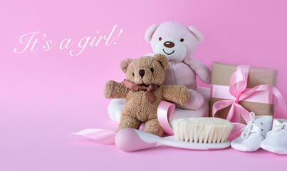 Greeting card for baby girl birth with teddy bears and baby hair brush on pink background. With It's a girl! inscription in english