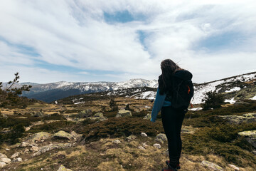 young woman standing looking at mountain landscape. Snowy mountains