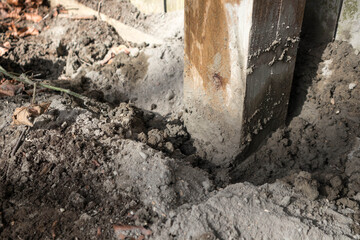 Wooden fence post being concreted into the ground for fence repair