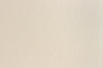 The surface of artificial beige leather used for furniture upholstery. Uniform light texture.