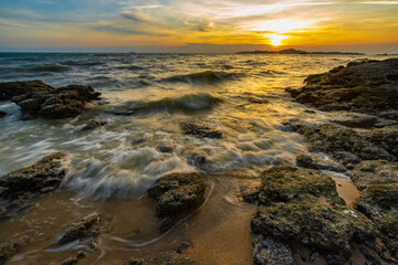 Sea waves crashed against rocks in the sunset at Pattaya Thailand.