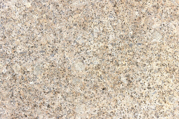 The texture of a hewn granite slab with a colorful pattern. Facing material for walls made of natural stone.