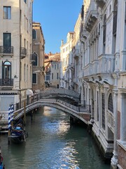 Fototapeta na wymiar Beautiful bridge over a small canal lined, on colorful building background, Venice, Italy, during Lockdown Crisis COVID-19