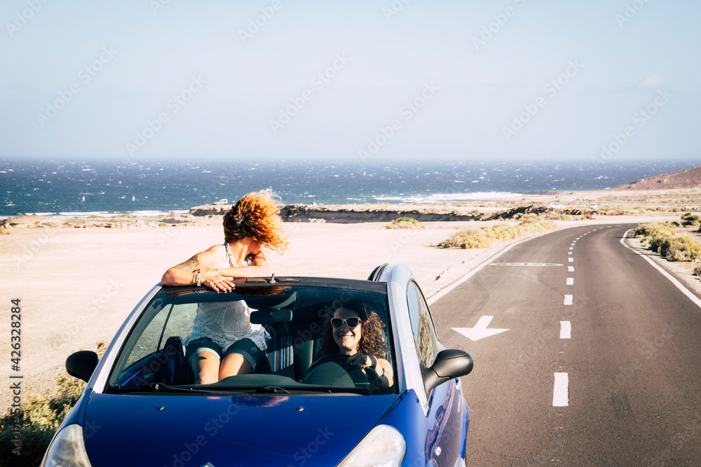 Wall mural car travel friends transportation two happy woman ejoy convertible auto together in summer trip holi