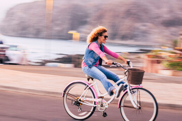 Blurred and motion picture with cheerful joyful young woman enjoying bike ride and have fun outdoor...