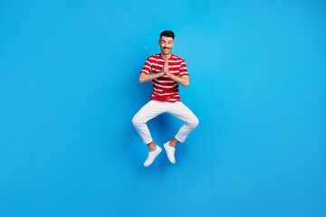 Fototapeta na wymiar Full body photo of attractive cheerful guy jump up air clap hands isolated on pastel blue color background