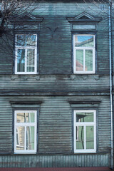 old wooden turquoise colour house facade with four windows