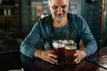 middle aged barman serving beer in pub