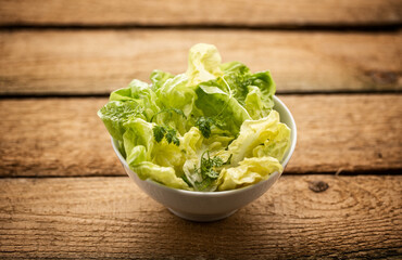 Frischer Salat in einer Schüssel auf Holzbrett