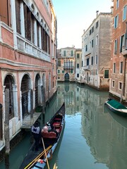 Fototapeta na wymiar Tourist visiting Venice on a gondola on a small canal street in Venice, Italy