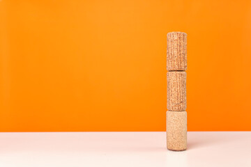 Wine corks on white table against bright orange background. Minimalistic, vivid colors.
