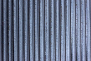 Corrugated sheet metal, badly painted with gray paint for background. Metal corrugated roofing sheet.Painting of metal surfaces for rust control Abstract background for sites and layouts. Iron fence