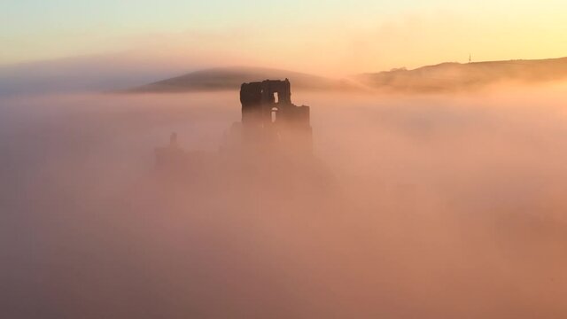 Corfe Castle covered in fog at sunrise