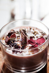 Detail of a candle with red dried flowers, semi-precious stones and glitter.