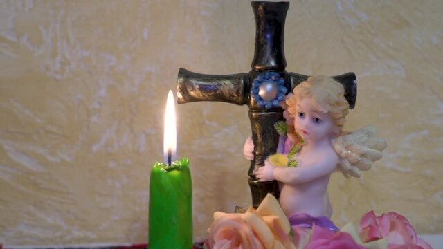 angel with a cross and a candle,religious statuette of an angel holding a cross and a burning candle