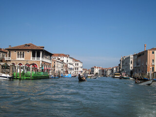 Venice old city grand canal with gondolas and boats. Romantic swimming in the morning. Comfotrable transportation to ancient historic hotel. Scenic Venetian scape on a sunny day.