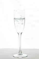 Filling up the champagne glass water  isolated on a white background