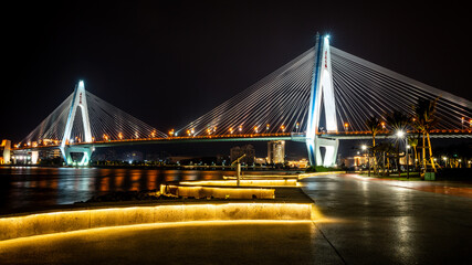 Beautiful scenic view of the century bridge with illuminated promenade at night along the Haikou landmark coastline in Haikou Hainan China