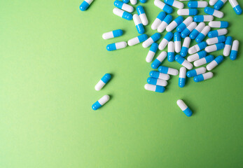 white and blue pills on green background