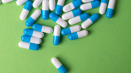 white and blue pills on green background